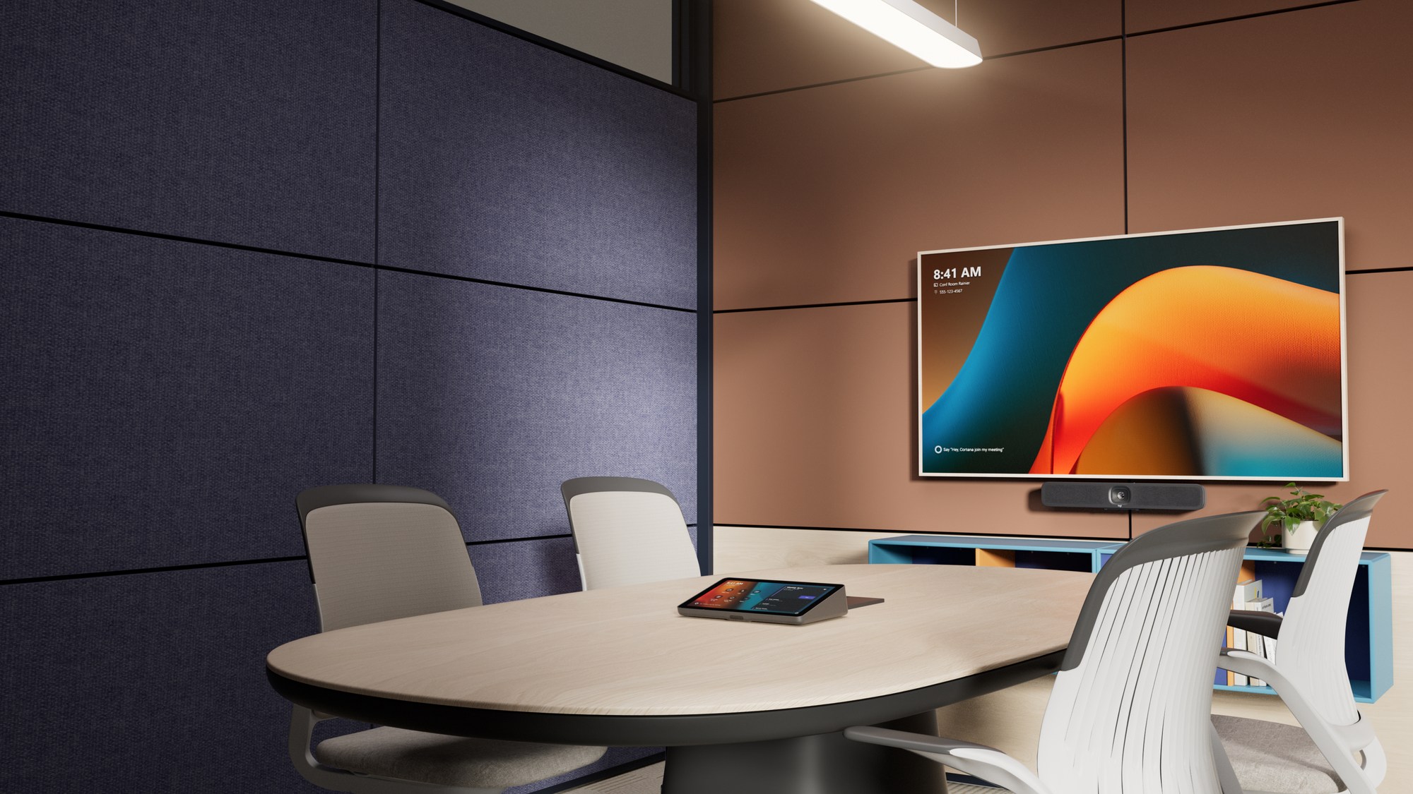 Sala de reunión con Logitech MeetUp 2 bajo una pantalla que muestra la interfaz de Microsoft Teams y un controlador táctil sobre la mesa.